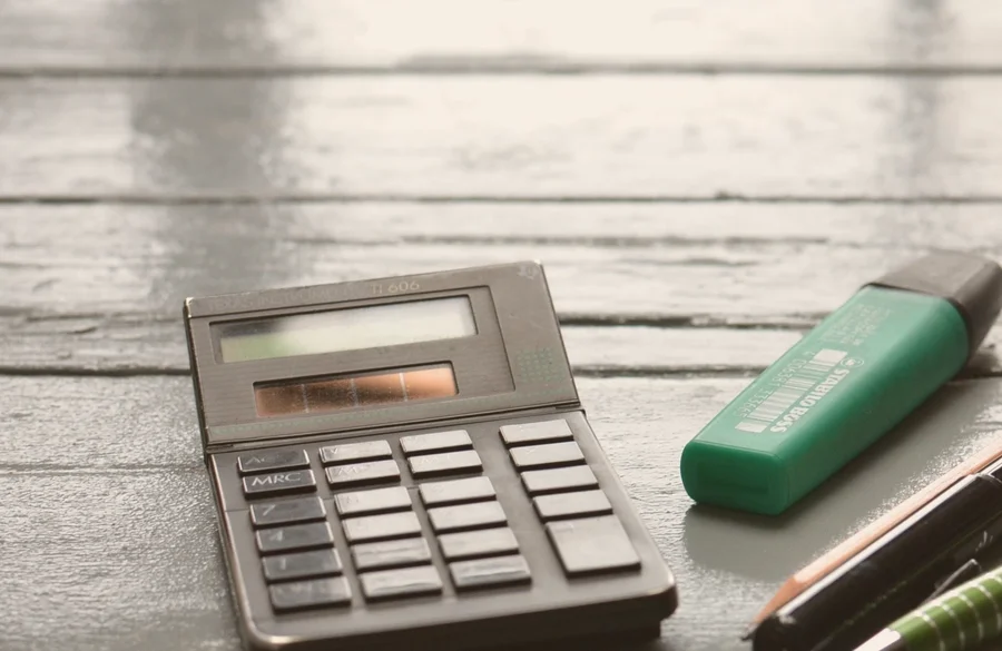 A calculator and stationery on a desk
